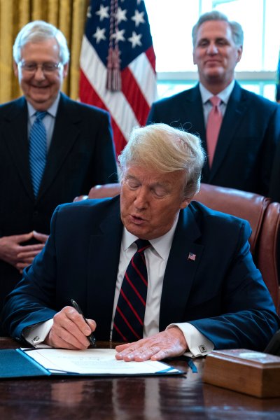 In this March 27, 2020 file photo, President Donald Trump signs the coronavirus stimulus relief package in the Oval Office at the White House in Washington, as Treasury Secretary Steven Mnuchin, Senate Majority Leader Mitch McConnell, R-Ky., House Minority Leader Kevin McCarty, R-Calif., and Vice President Mike Pence watch. Payments from a federal coronavirus relief package could take several weeks to arrive. While you wait, prep your finances and make a plan for using any money you receive.