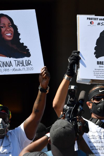 Signs are held up showing Breonna Taylor during a rally in her honor on the steps of the Kentucky State Capitol in Frankfort, Ky., Thursday, June 25, 2020.
