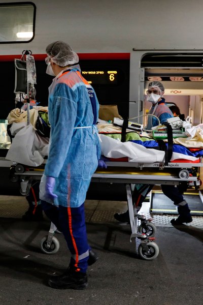 Medical staff transport a patient infected with the coronavirus onto a train at the Gare d'Austerlitz train station Wednesday April 1, 2020 in Paris. France is evacuating 36 patients infected with the coronavirus from the Paris region onboard two medicalized high-speed TGV trains.