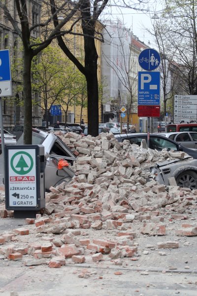 Fallen rubble smashes a parked car