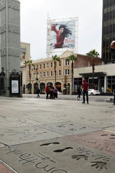 A man takes a picture of the hand and footprints of actor Tom Hanks in the forecourt of the TCL Chinese Theatre