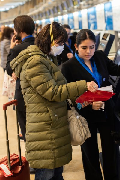 A passenger waring a protective masks gets her boarding card at Adolfo Suarez-Barajas international airport on the outskirts of Madrid, Spain, Wednesday, March 11, 2020.