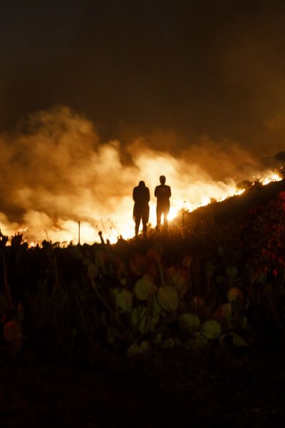 People watch from a hillside during the Silverado Fire.