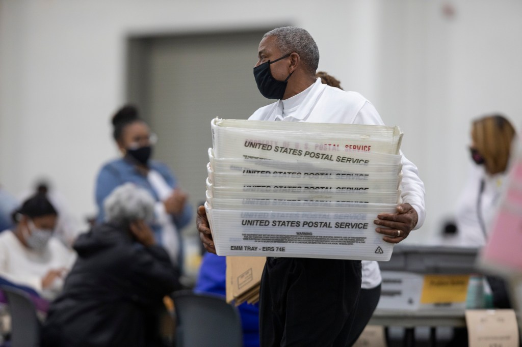 A worker with the Detroit Department of Elections carries empty boxes used to organize absentee ballots after nearing the end of the absentee ballot count at the Central Counting Board in the TCF Center on November 4, 2020 in Detroit, Michigan.