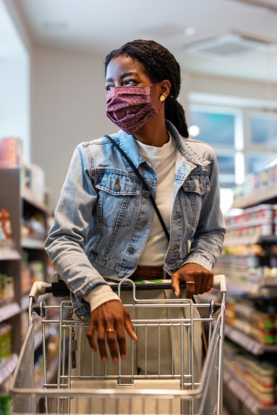 Woman wearing protective face mask buying groceries at a supermarket