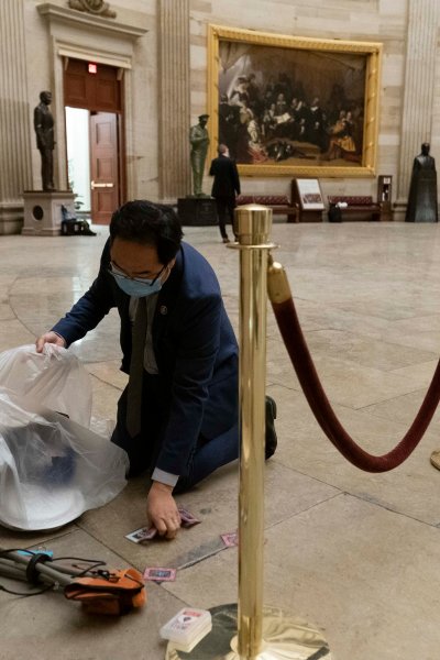 In this Jan. 7, 2021, file photo, Rep. Andy Kim, D-N.J., cleans up debris and personal belongings strewn across the floor of the Rotunda in the early morning hours after a pro-Trump mob stormed the U.S. Capitol.