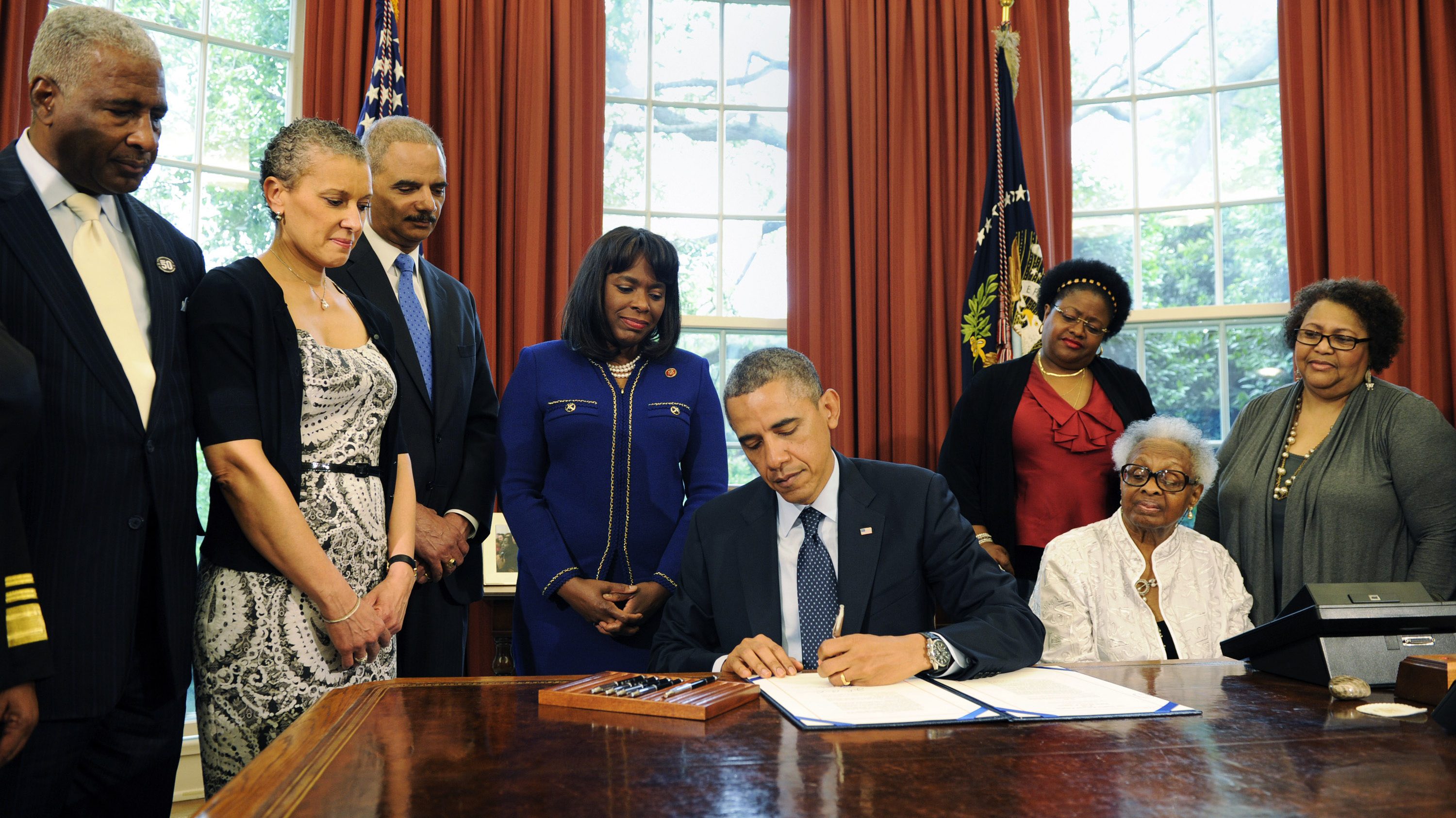 Barack Obama designates the Congressional Gold Medal to commemorate the four young girls killed during the 1963 bombing of 16th Street Baptist Church in Birmingham, Alabama, as Birmingham Mayor William Bell, Dr. Sharon Malone Holder, Attorney General Eric Holder, Rep. Terri Sewell, Thelma Pippen McNair, Lisa McNair and Dianne Braddock look on May 24, 2013, in Washington, D.C. 