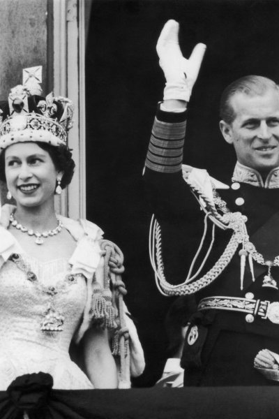 Queen Elizabeth II and the Duke of Edinburgh wave at the crowds from the balcony at Buckingham Palace on June 2, 1953.
