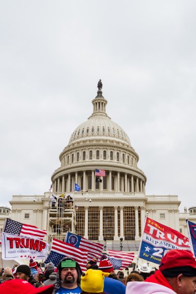 A large group of pro-Trump protesters raise signs and flags on the grounds of the Capitol Building on January 6, 2021 in Washington, DC. A pro-Trump mob stormed the Capitol earlier, breaking windows and clashing with police officers. Trump supporters gathered in the nation's capital today to protest the ratification of President-elect Joe Biden's Electoral College victory over President Trump in the 2020 election.