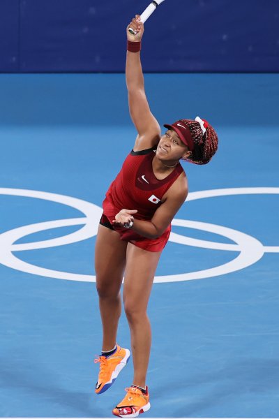 Naomi Osaka serves during a tennis match.