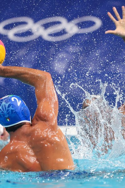 A water polo player for Italy holds up the ball in the water