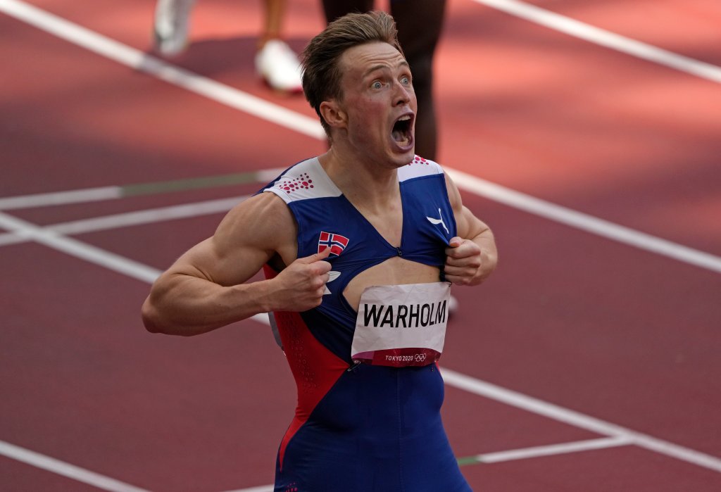 Karsten Warholm, of Norway celebrates, ripping his shirt, as he wins the gold medal and sets a new record in the final of the men's 400-meter hurdles at the 2020 Olympics, Tuesday, Aug. 3, 2021, in Tokyo, Japan.