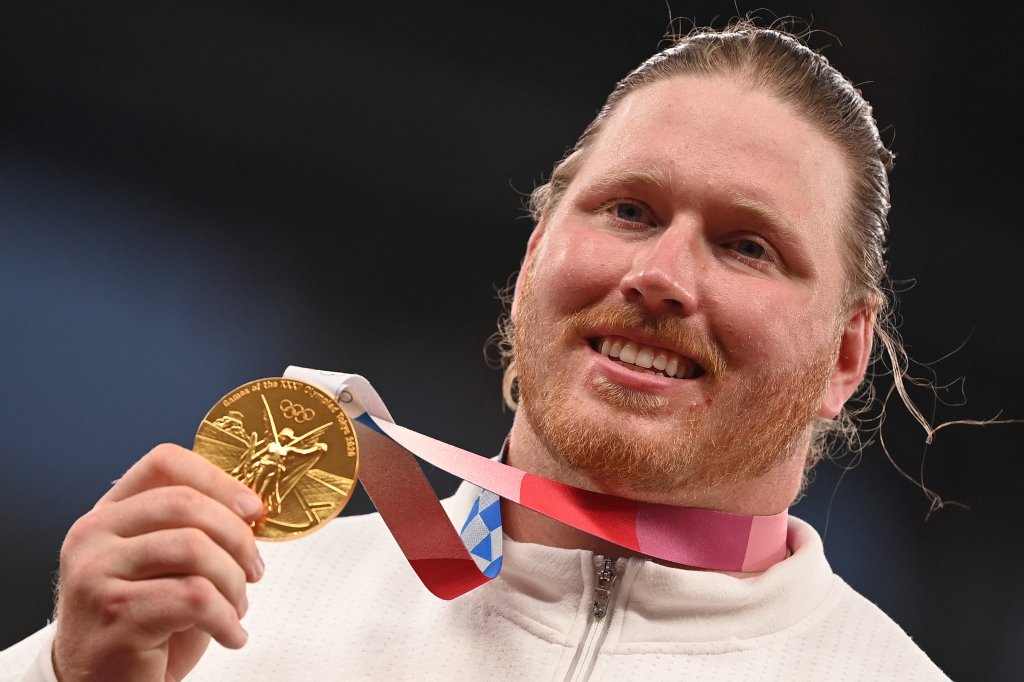 Gold medallist USA's Ryan Crouser poses on the podium after the men's shot put event during the Tokyo 2020 Olympic Games at the Olympic stadium in Tokyo on Aug. 5, 2021. 