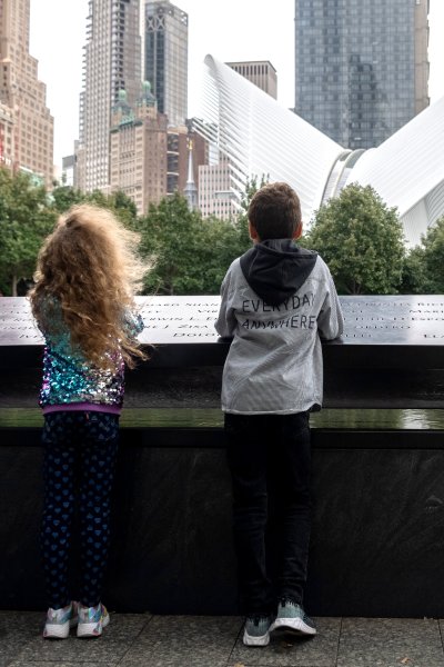 Children visit the North reflecting pool at the September 11th Ground Zero Memorial Plaza