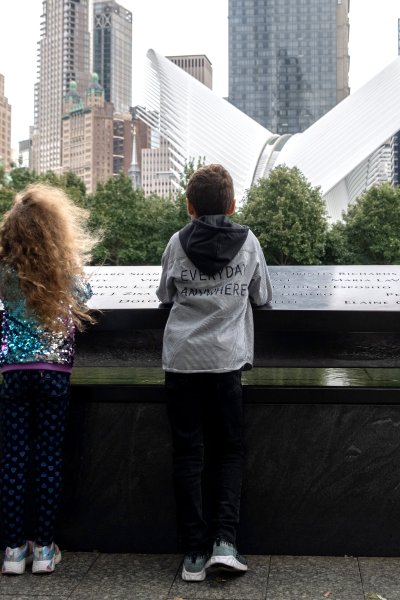 Children visit the North reflecting pool at the September 11th Ground Zero Memorial Plaza
