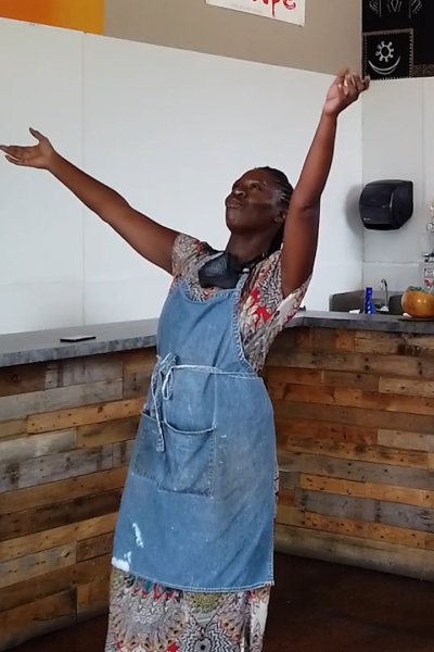 A woman dances in her cafe