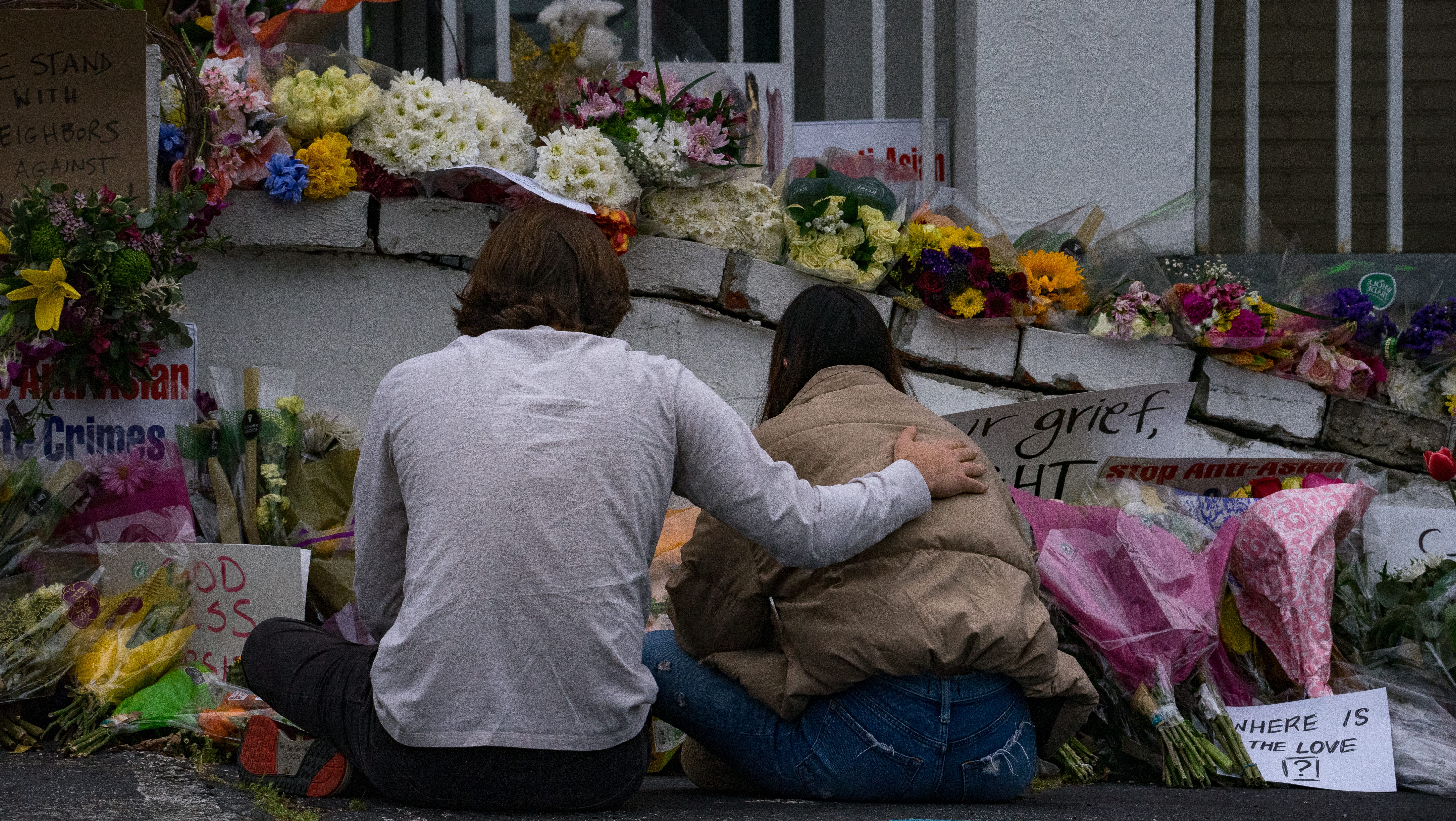 People bring flowers to the memorial sight set up outside of The Gold Spa on March 19, 2021 in Atlanta, Georgia.