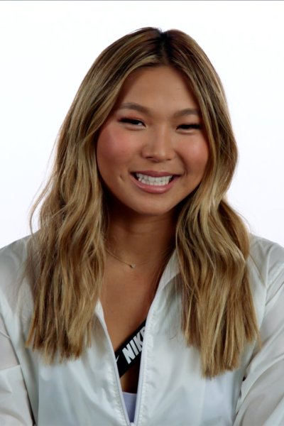 Snowboarder Chloe Kim smiles during an interview with a white backdrop.