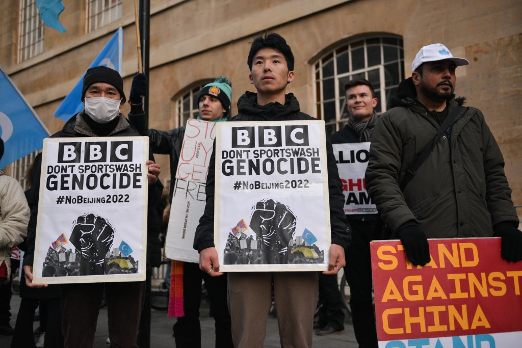 Activists hold placards saying BBC Don't Sportswash Genocide