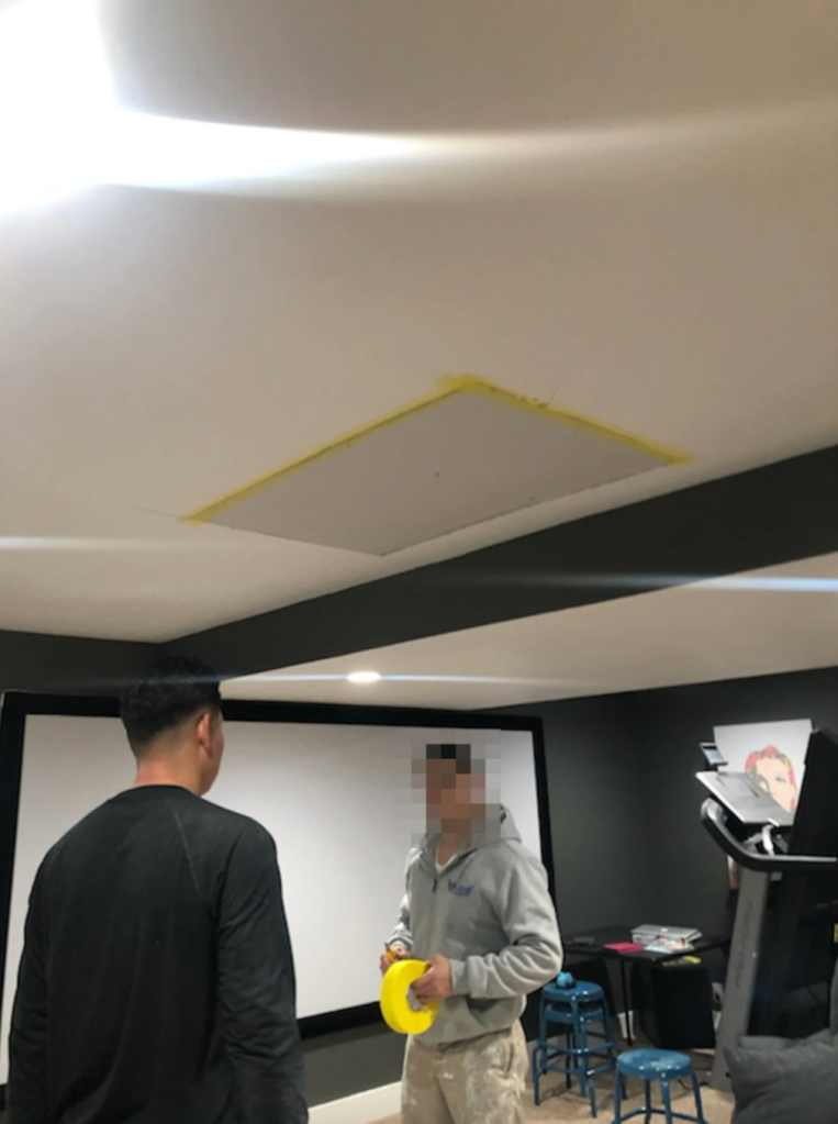 A photo provided by Jeff Hawley shows a hole in the ceiling being patched up after he said a construction worker fell through into the basement.