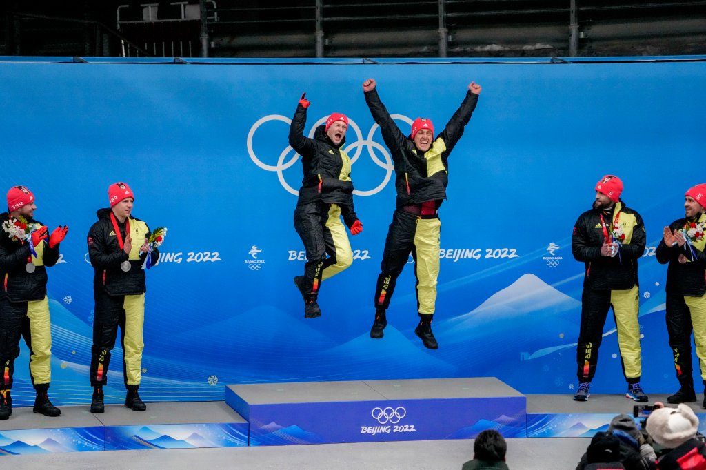 Francesco Friedrich and Thorsten Margis, of Germany, celebrate winning the gold medal in the 2-man bobsleigh at the 2022 Winter Olympics