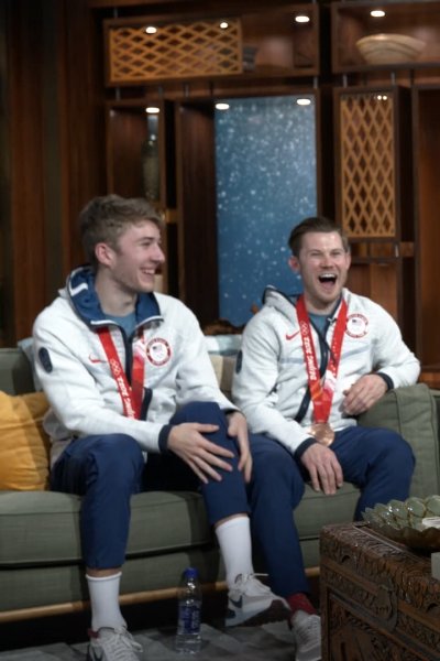 Four U.S. speed skaters sit on two couches together