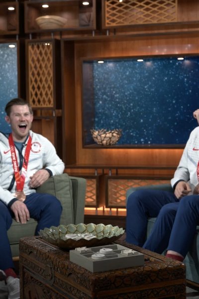 Four U.S. speed skaters sit on two couches together