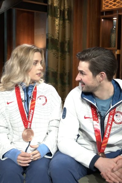 Zachary Donohue and Madison Hubbell sit on a couch together
