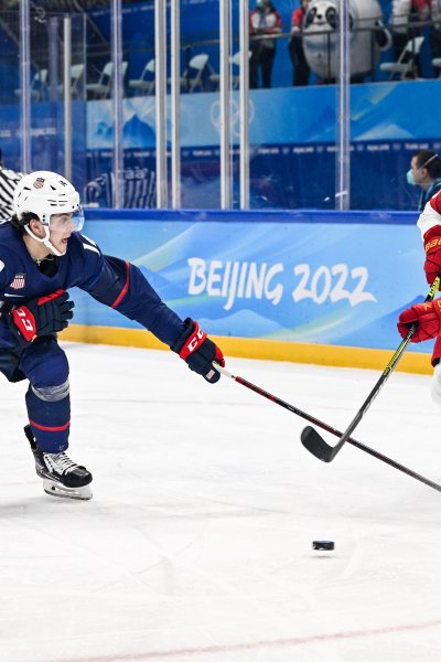 Brock Faber of Team USA and Wei Zhong of Team China battle for the puck at the men's ice hockey preliminary round match during the 2022 Winter Olympics in the National Indoor Stadium, Feb. 10, 2022, in Beijing, China.