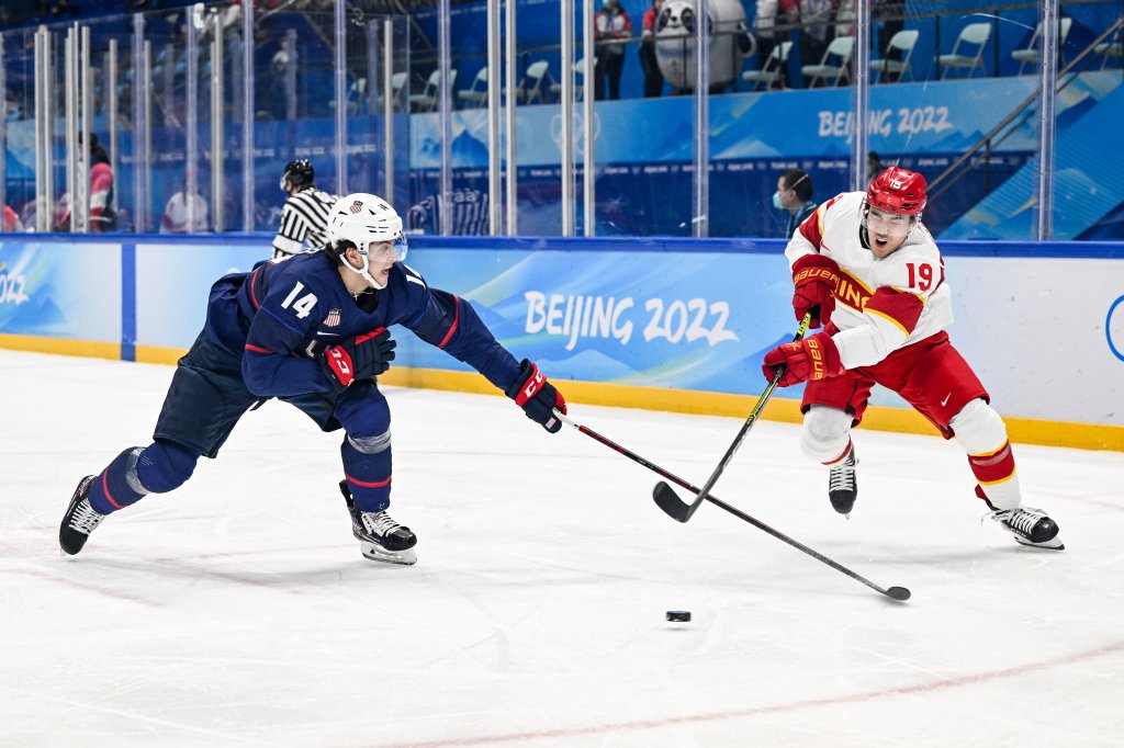 Brock Faber of Team USA and Wei Zhong of Team China battle for the puck at the men's ice hockey preliminary round match during the 2022 Winter Olympics in the National Indoor Stadium, Feb. 10, 2022, in Beijing, China. 