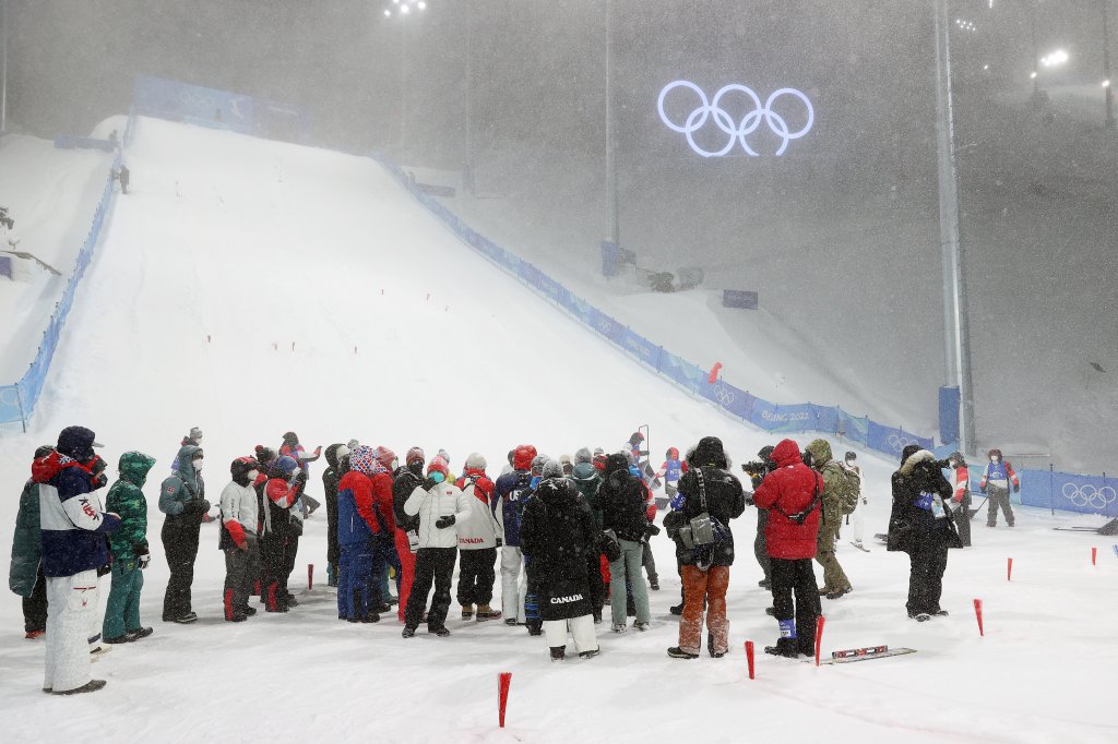 Officials and team staff gather as the Women's Freestyle Skiing Aerials qualifications are postponed due to weather at Genting Snow Park for the 2022 Winter Olympics, Feb. 13, 2022, in Zhangjiakou, China.