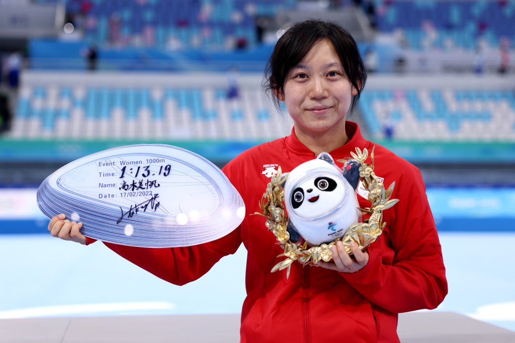Gold medallist Miho Takagi of Team Japan poses with a board showing her new Olympic record time of 1:13.19 for the Women's 1000m speed skating competition at the 2022 Winter Olympics, Feb. 17, 2022, in Beijing.