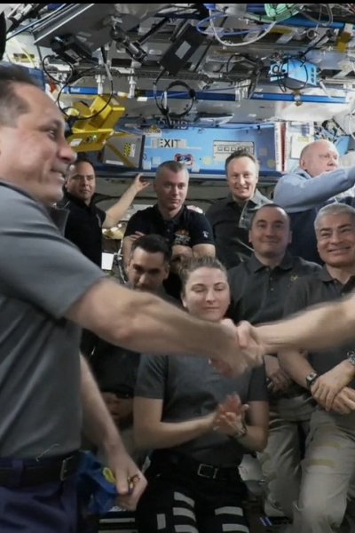 Russian Cosmonaut shakes hand of NASA astronaut