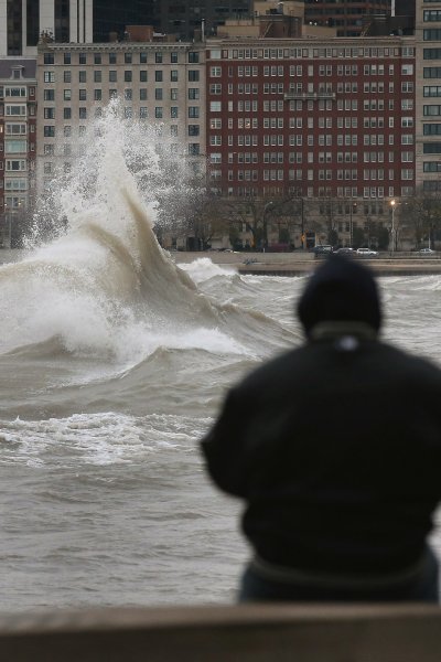 A man watches waves generated from the remnants Hurricane Sandy as they crash into the shoreline of Lake Michigan on October 30, 2012 in Chicago, Illinois.
