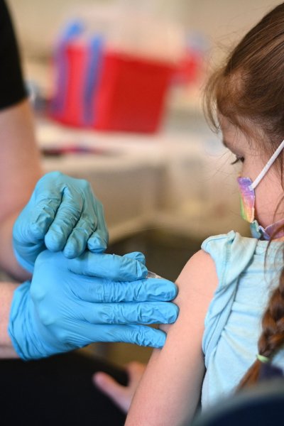 A nurse administers a pediatric dose of the Covid-19 vaccine to a girl at a L.A. Care Health Plan vaccination clinic at Los Angeles Mission College