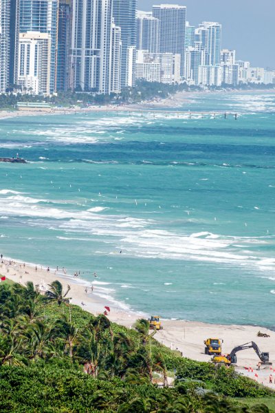 Florida, Miami Beach, North Beach, Sunny Isle, beach restoration equipment widening beach due to erosion from climate change.