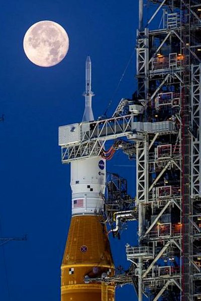 NASA's Artemis rocket at night with moon in background