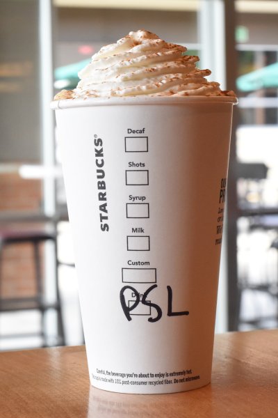 To go Starbucks cup with whipped cream and PSL written in marker.