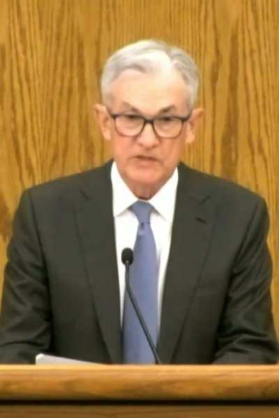 Jerome Powell holds press conference in front of wooden backdrop